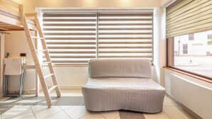 A room with a bed, a ladder, a window with blinds, and a view of the street. - Le Local - Climatisation - Petfriendly (Saint-Martin-d'Hères)