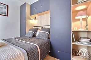 Ein Schlafzimmer mit einem Bett, Nachttischen, einer Lampe und einem Regal mit Büchern.