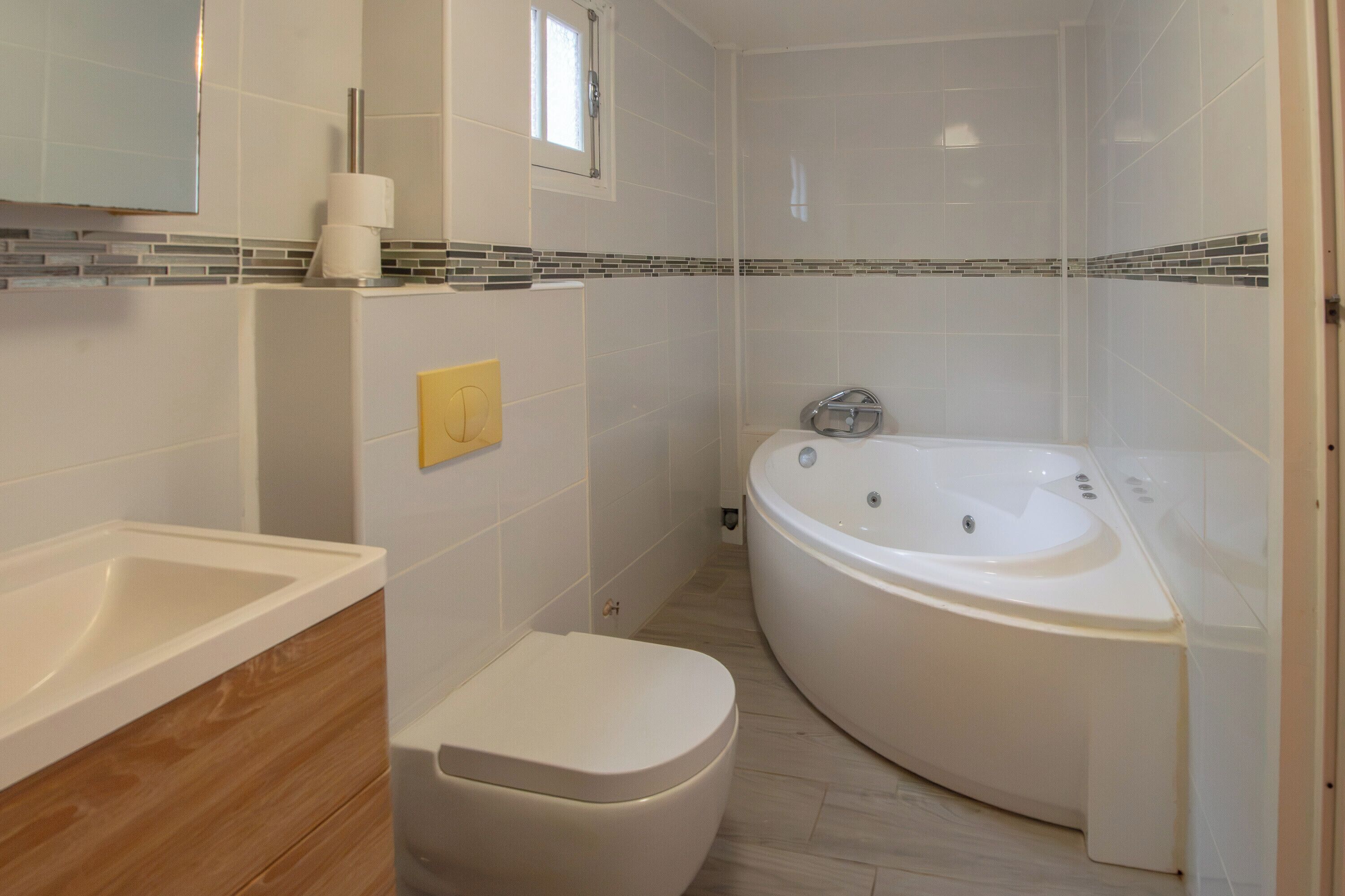 Ein modernes Badezimmer mit einer freistehenden Badewanne, einer Toilette und einem Waschbecken.