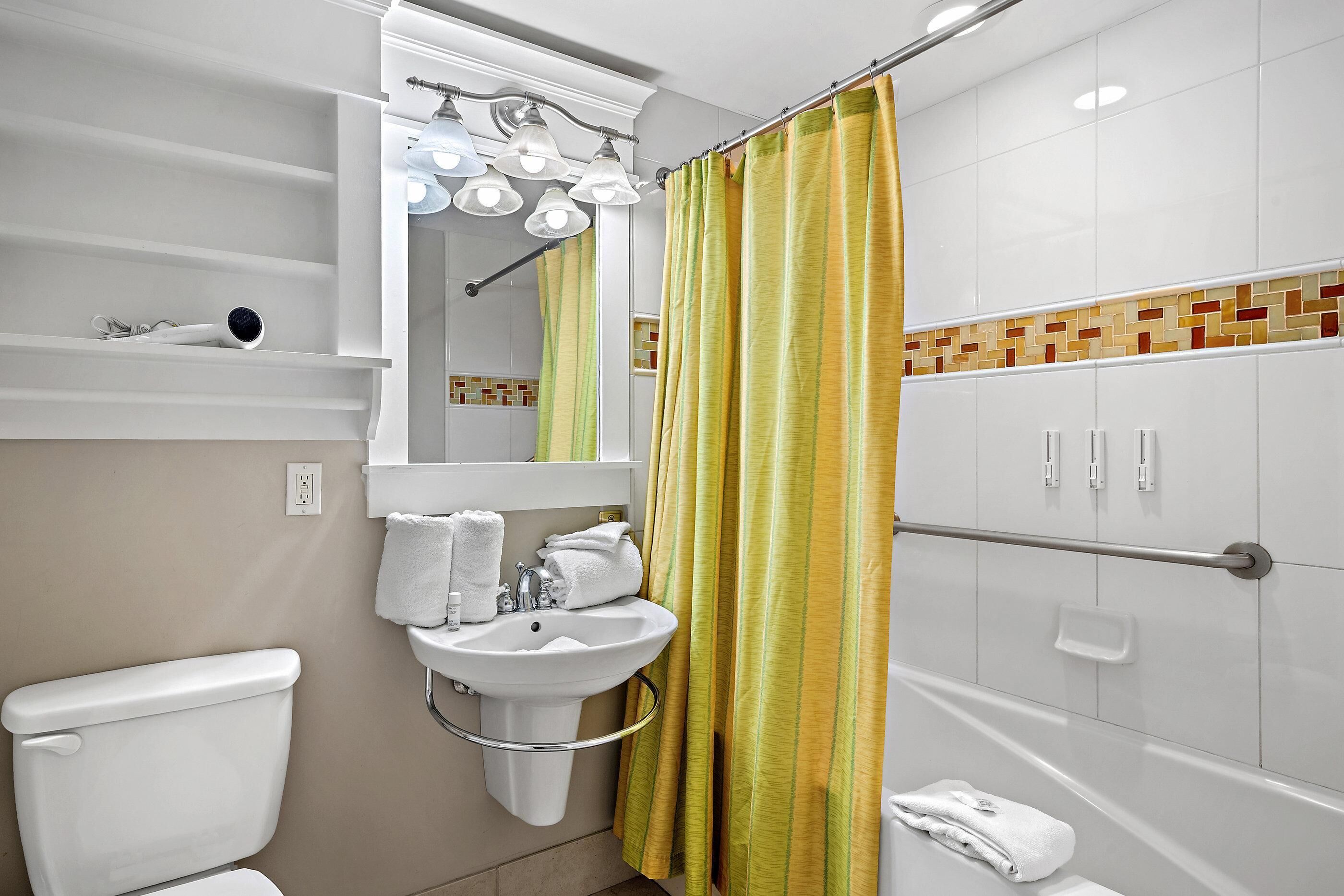 Een badkamer met toilet, wastafel en douche.