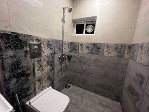 A bathroom with a shower, toilet, and a small window. - 2-bedroom apartment in fantastic Lahore with cool AC Near Airport (Lahore)