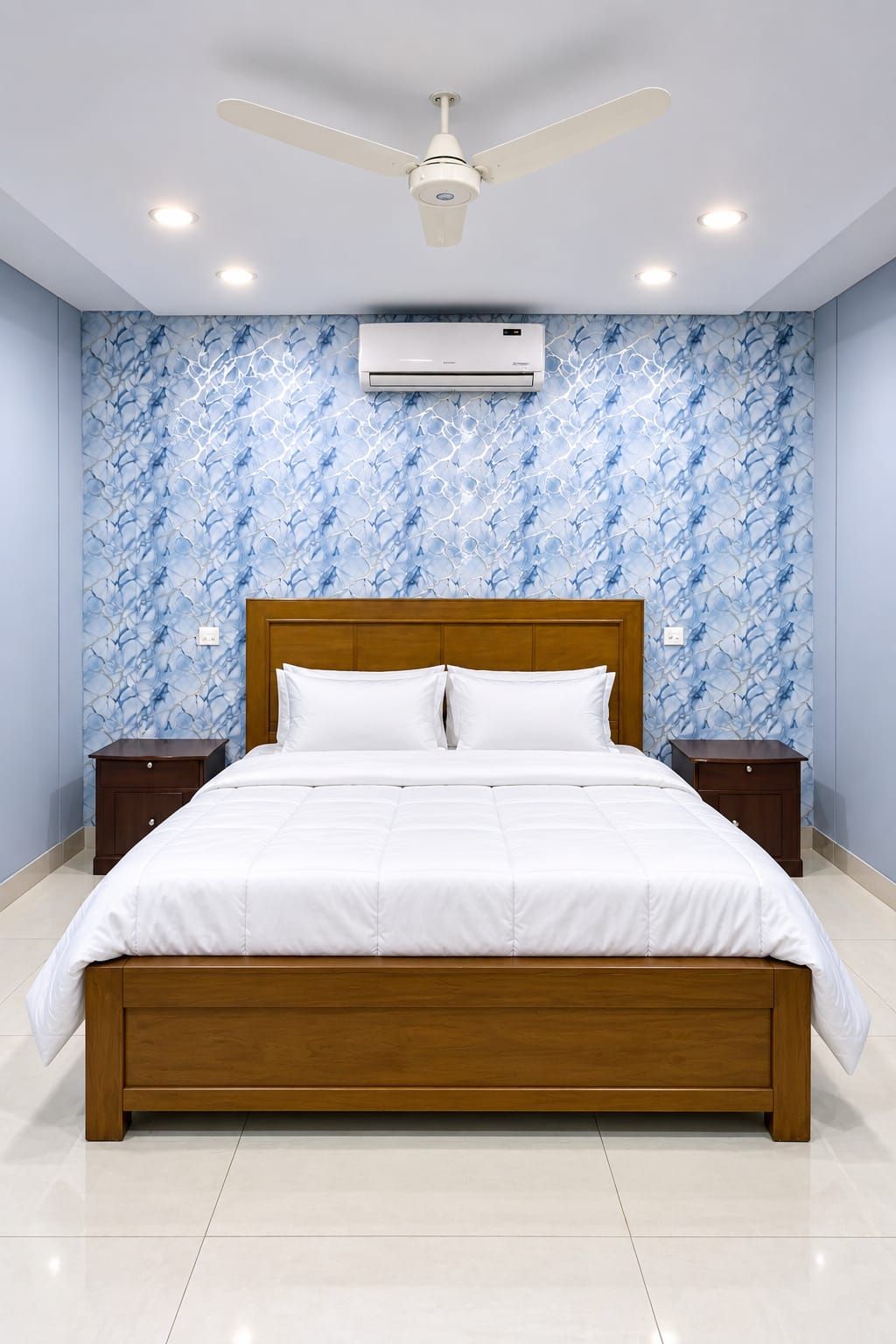 Quarto com cama, mesas de cabeceira, ventilador de teto e ar condicionado.