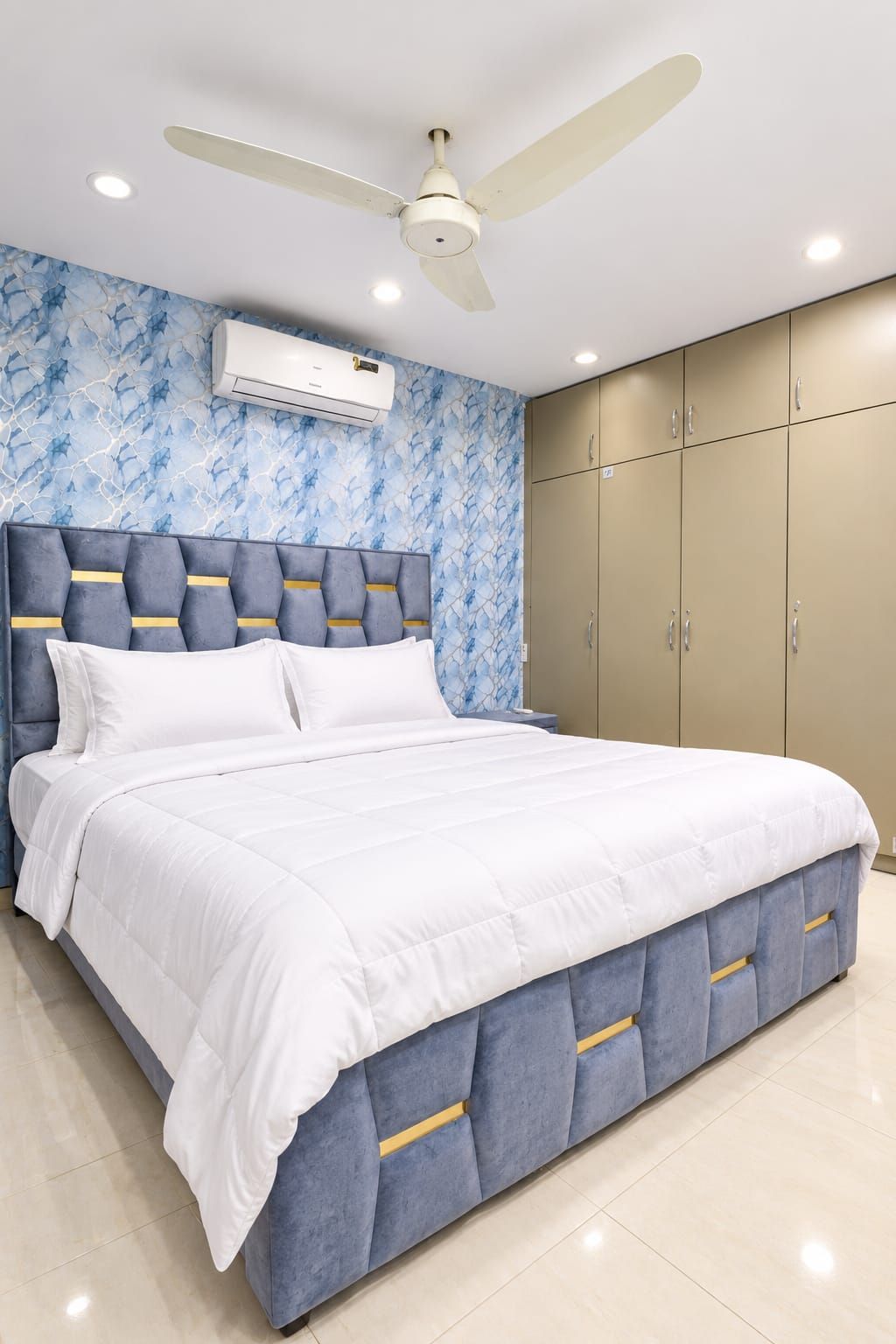 A bedroom with a bed, a ceiling fan, and a wardrobe.
