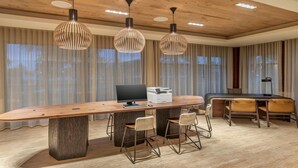 Een moderne keuken met een houten keukeneiland, hanglampen en een eethoek met stoelen.