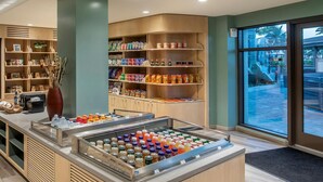 Een hotel lobby met een drankendisplay, planken vol snacks en een groot raam met uitzicht.