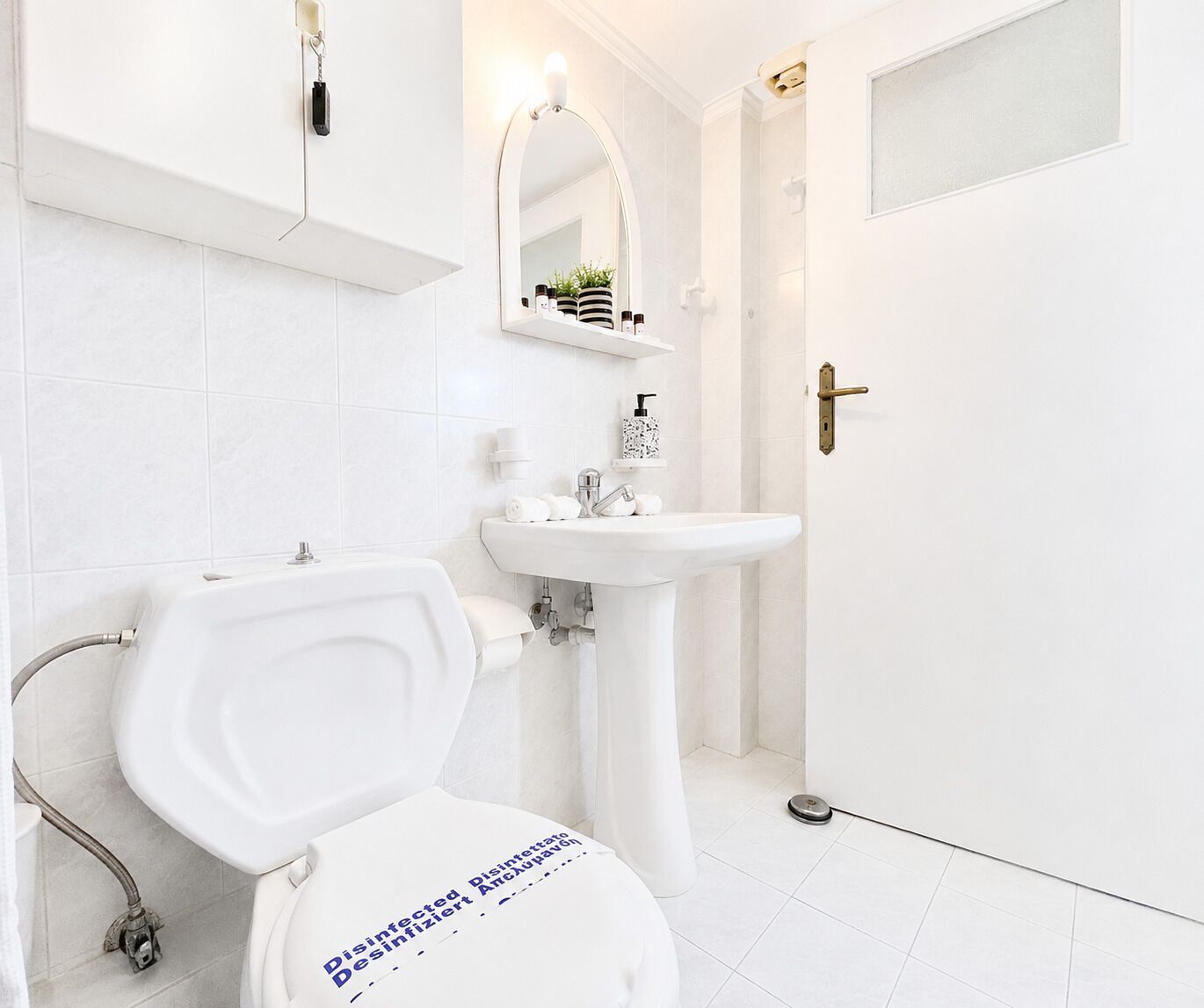 Un baño con inodoro, lavamanos y espejo.