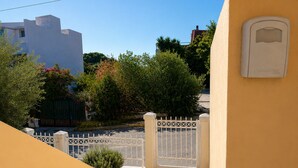 A gated entrance with a tiled pathway leading to a building.