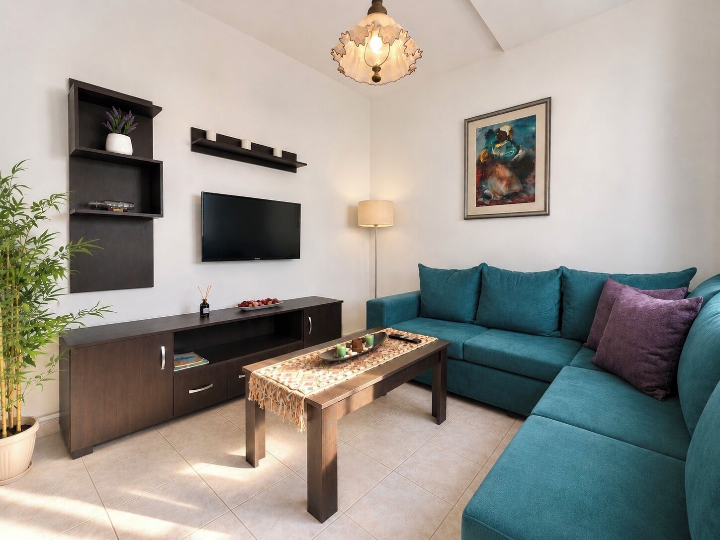 Een moderne woonkamer met een blauwgroene bank, een houten salontafel, een flatscreen televisie en een schilderij aan de muur.