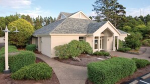 A single-story building with a sloped roof, a front entrance, and a pathway leading to the entrance. - WM BLOCK Gleneden - 1br (Lincoln Beach)