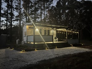 A house with a covered porch, a visible door, and a small outdoor seating area.