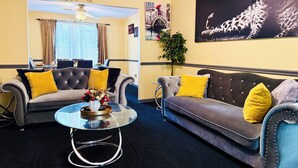 Un salon avec deux canapés, une table basse et un mur orné d’une œuvre d’art à motifs léopard.