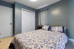 A bedroom with a bed, a wardrobe, and a door. - Perfect 3-bedroom house with AC in welcoming Birmingham. (Birmingham)