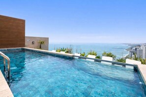 A rooftop infinity pool with a clear view of the ocean and city skyline. - Sight 1601 · Luxe King Bed 1BR •Rooftop Pool, Gym, AC & Parking (Lima)