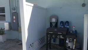 A patio area with a barbecue grill, a water dispenser, and a trash can. - Charming 1-bedroom studio near Venice Beach (Venice)