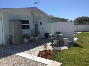 A single-story house with a front porch, a small patio area with a table and chairs, and a fenced yard. - Charming 1-bedroom studio near Venice Beach (Venice)