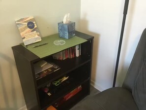 Ein Bücherregal mit einer Taschentuchbox und einem gerahmten Zertifikat.