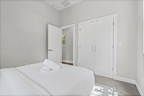 Ein Schlafzimmer mit einem Bett, einer weißen Tür und einem Schrank.
