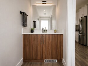 A modern kitchen with a stainless steel refrigerator, wooden cabinets, and a white countertop. - Newest Nordix Townhome Premium ski in/out Location (Panorama)