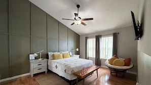 A bedroom with a bed, bedside table, lamp, and a ceiling fan. - Lyrios Vacation Rentals - The Villas (Kissimmee)