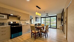 A modern kitchen with a dining area, large windows, and a view of the city. - Cozy 1 bedroom apartment with AC in San Salvador (San Salvador)