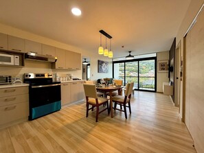 A modern kitchen with a dining area, large windows, and a view of the city. - Cozy 1 bedroom apartment with AC in San Salvador (San Salvador)