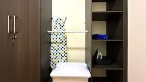 A storage closet with shelves, a hanging rack, and a ironing board. - Cozy 1 bedroom apartment with AC in San Salvador (San Salvador)