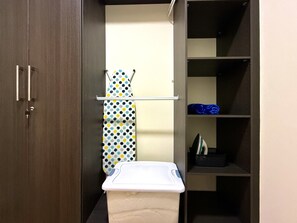 A storage closet with shelves, a hanging rack, and a ironing board. - Cozy 1 bedroom apartment with AC in San Salvador (San Salvador)