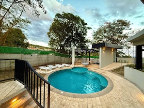 A swimming pool with lounge chairs, a pergola, and a view of the surrounding landscape. - Cozy 1 bedroom apartment with AC in San Salvador (San Salvador)
