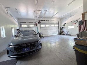Eine Garage mit einem Auto, einer Werkbank und einer US-amerikanischen Flagge.