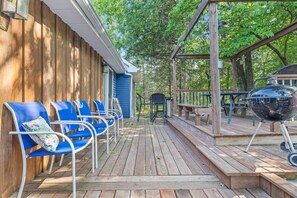 A wooden deck with outdoor seating and a barbecue grill.