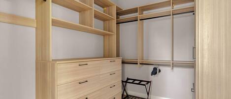 Un vestidor con estanterías de madera, cómoda empotrada y zapatero.