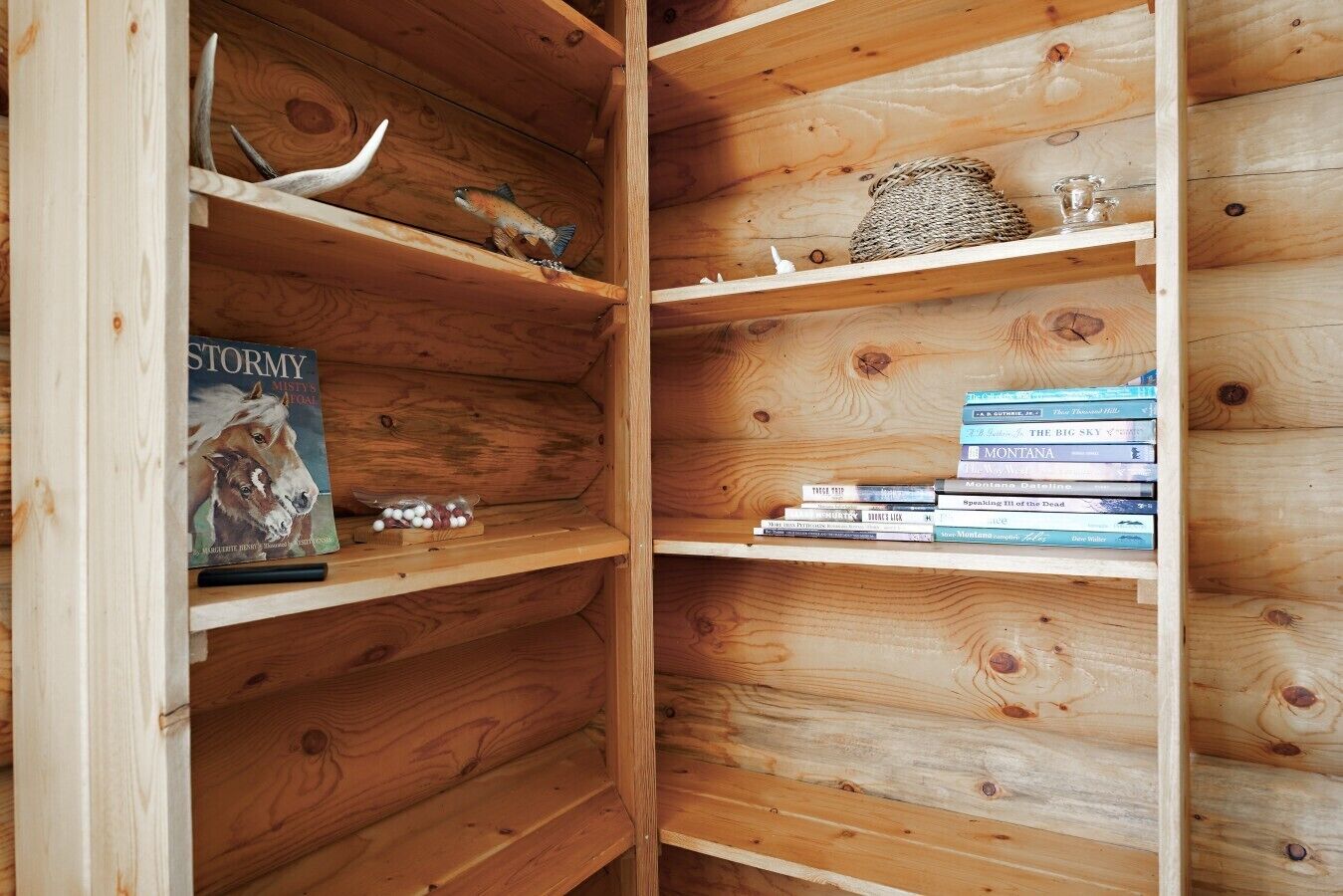 A wooden bookshelf with books and decorative items.
