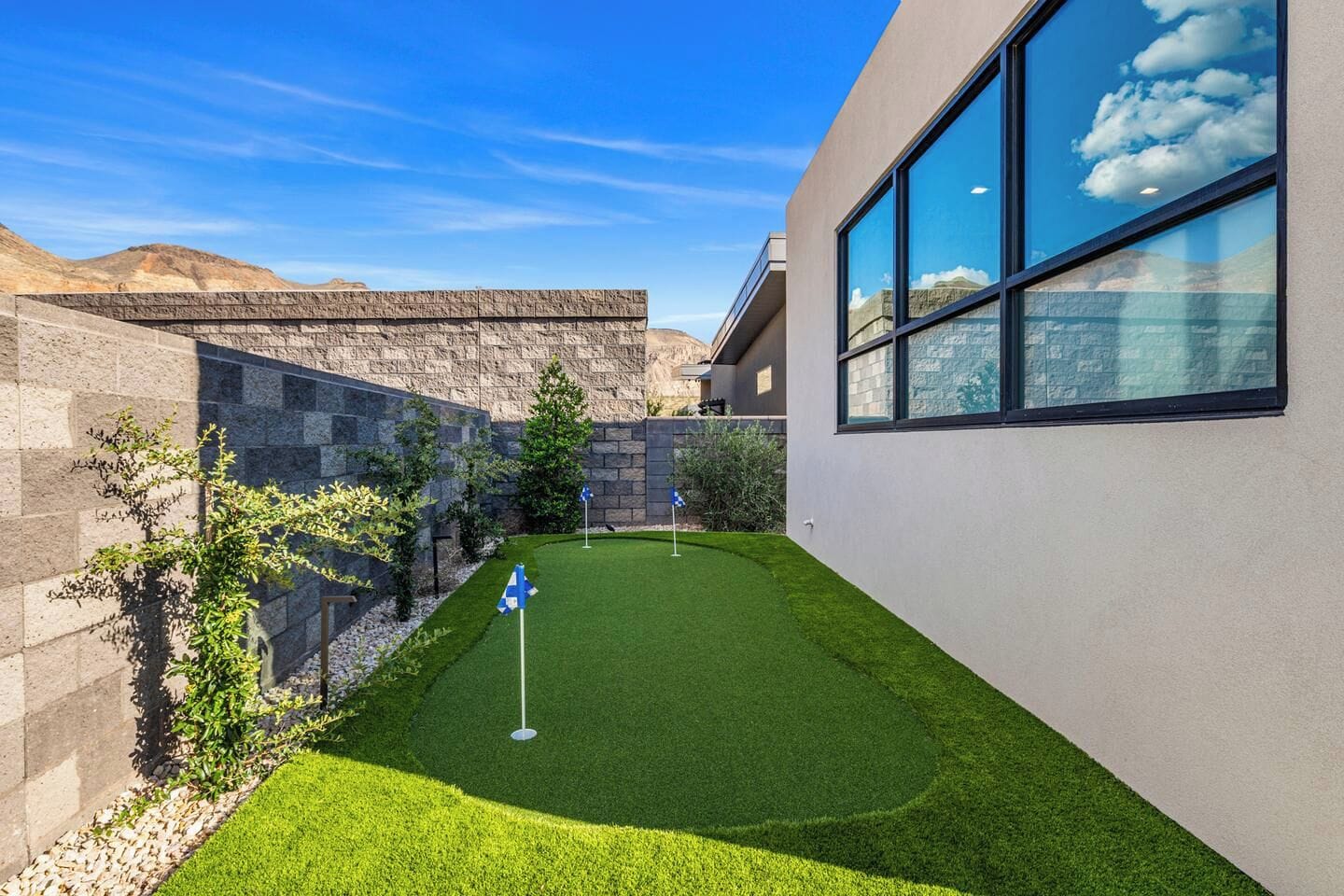 A modern building with a well-maintained lawn and stone walls.