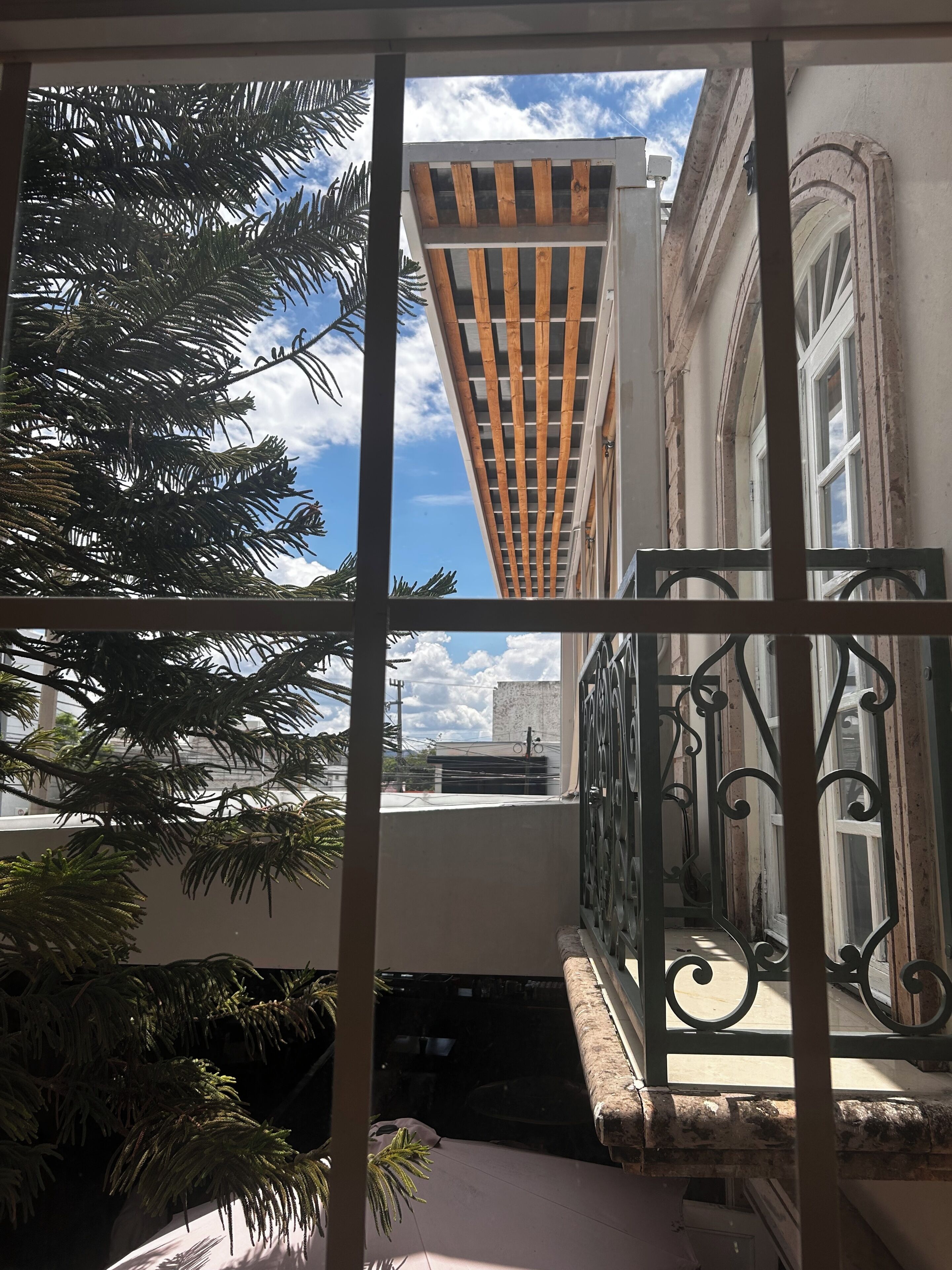 A balcony with a view of a building and a clear sky.