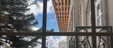 Un balcón con vista a un edificio y un cielo despejado.