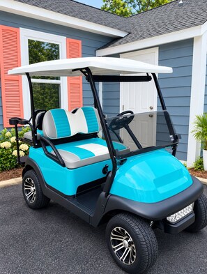 Un golf cart parcheggiato di fronte a una casa con un garage.