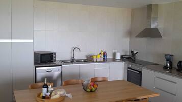 Una cocina moderna con una mesa de comedor, sillas y un sofá.