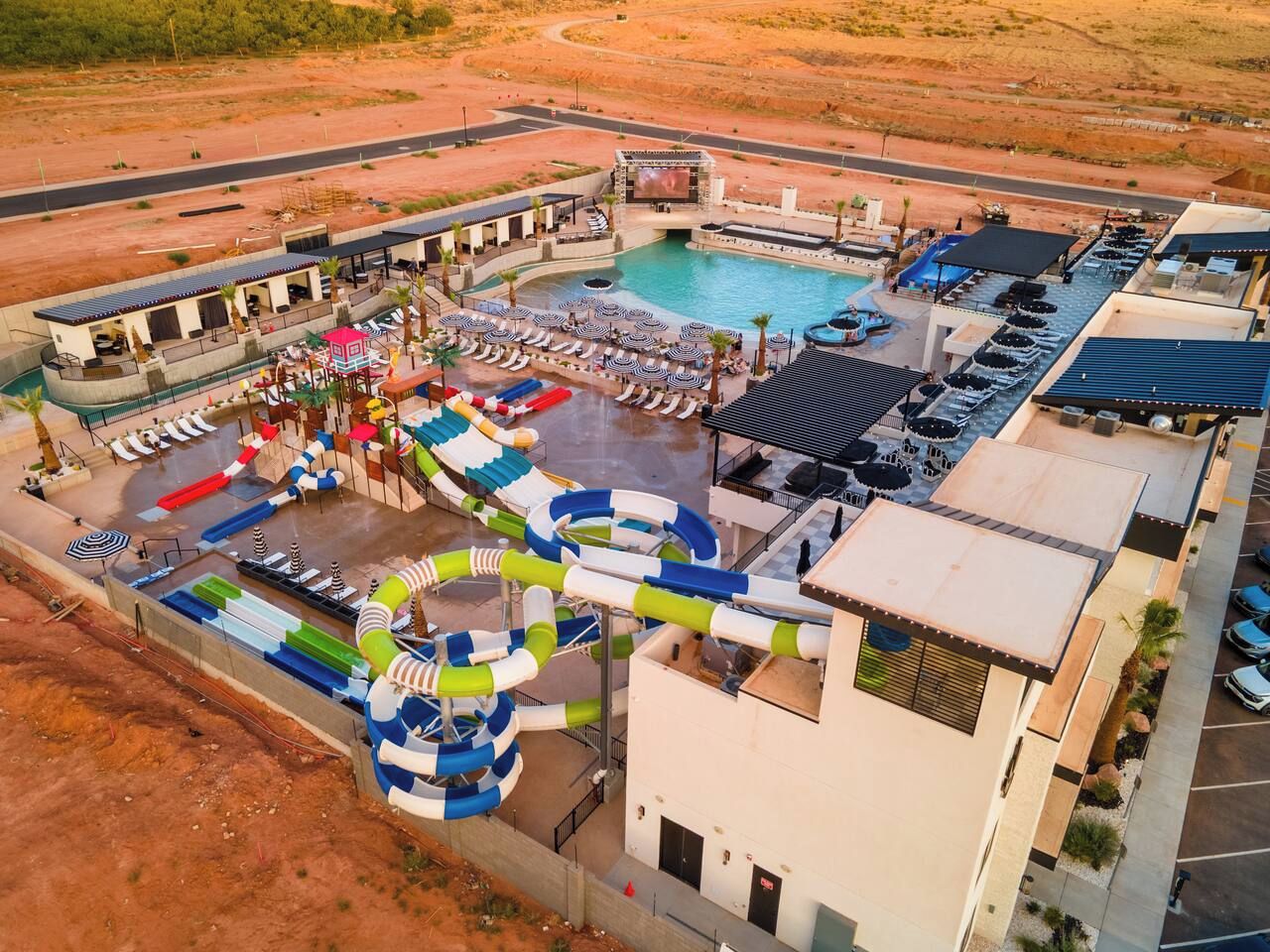 Parque acuático con piscina, toboganes y zonas de descanso.
