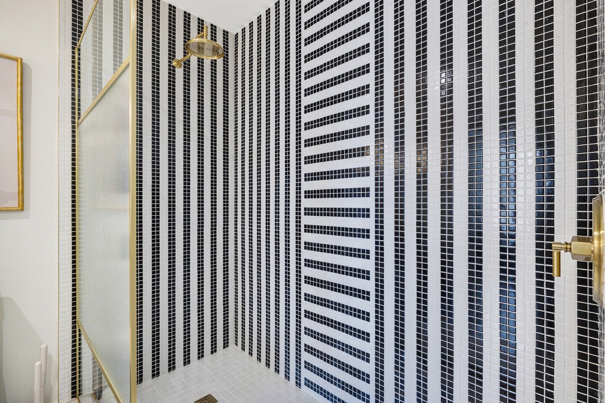 Un bagno con una parete piastrellata caratterizzata da un motivo bianco e nero.