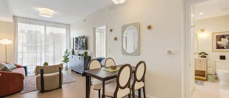 Un salon moderne comprenant un coin repas, un canapé, une table basse et une table à manger avec des chaises.