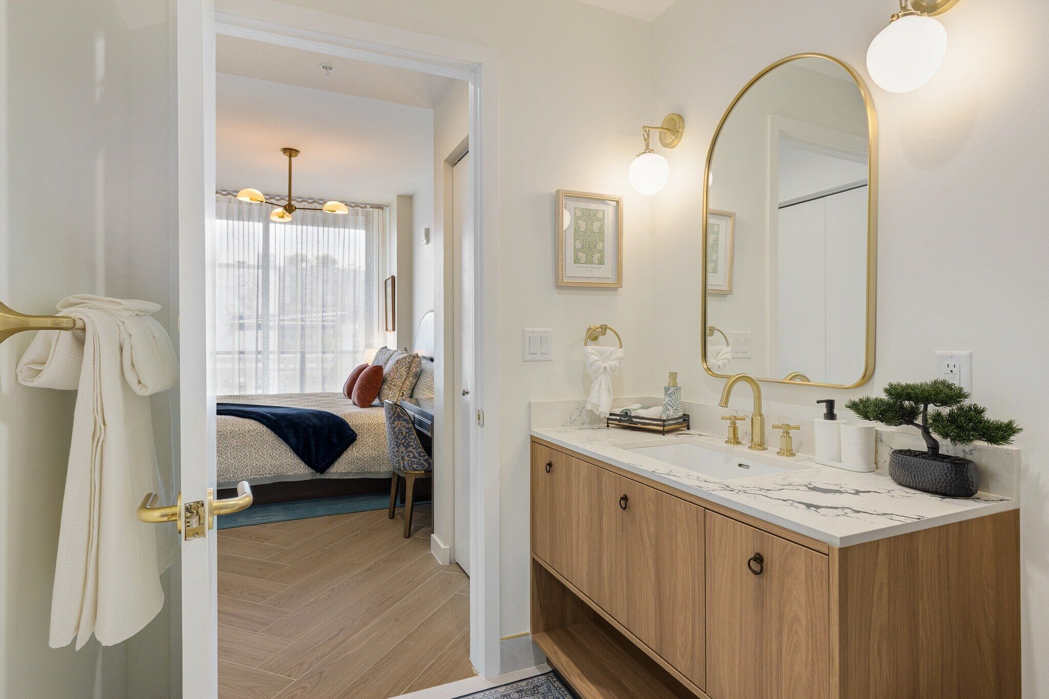 Un bagno moderno con un mobile lavabo, uno specchio grande e una pianta in vaso.