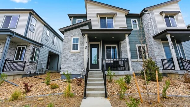 A row of townhouses with a central entrance, a small porch, and a stone facade. - Aurora Modern Retreat (Aurora)