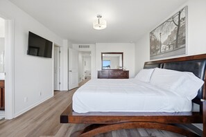 A bedroom with a large bed, a flat-screen TV, a dresser, and a mirror. - Central Park Denver 3BR and Loft Near Anschutz  DIA (Denver)