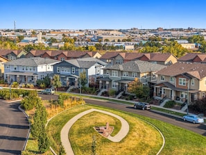 A residential area with townhouses, a curved driveway, and a clear sky. - Central Park Denver 3BR and Loft Near Anschutz  DIA (Denver)