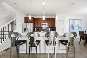 A modern kitchen with stainless steel appliances, wooden cabinets, and pendant lighting. - Central Park Denver 3BR and Loft Near Anschutz  DIA (Denver)