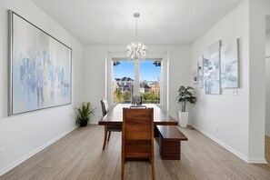 A dining room with a wooden table and chairs, a chandelier, and artwork on the walls. - Central Park Denver 3BR and Loft Near Anschutz  DIA (Denver)