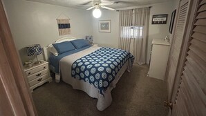A bedroom with a bed, a nightstand, a dresser, a ceiling fan, and a sign on the wall. - Lakefront Retreat Near Wisconsin Dells:  Kayak use Private Beach and Treehouse (Friendship)