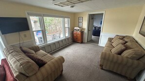 A living room with two couches, a television, and a door leading to a bedroom. - Lakefront Retreat Near Wisconsin Dells:  Kayak use Private Beach and Treehouse (Friendship)