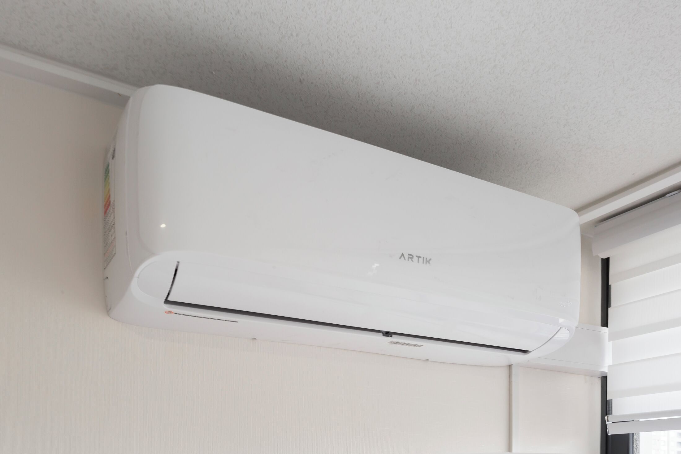 A white wall-mounted air conditioner with the brand name 'ARTIK' visible.
