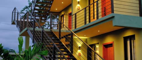 Un immeuble à plusieurs étages doté d’un escalier, de balcons et d’un extincteur.